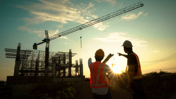 istock Silhouette of team engineer using laptop to control work, crane, construction site 1757499803