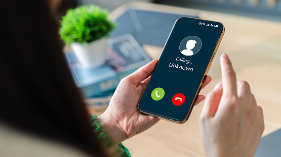 Human use smartphone with incoming call from unknown number, spam, prank caller, hoax person, fake identity, scammer, scam with mobile phone, hacker, call center, crime, call, fraud or phishing concept