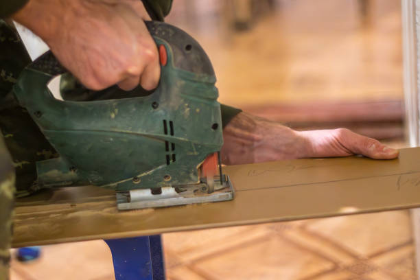전기 퍼즐을 사용하여 재활용 재료로 새로운 가구를 만드는 목수. 목수는 퍼즐을 사용하여 재료를 모양으로 자르고 결과 조각은 모든 가정에 지속 가능하고 세련된 추가 기능을 제공합니다. - carpenter home addition manual worker construction 뉴스 사진 이미지