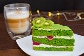 Pistachio cake with kiwi, cream and raspberry filling and Cappuccino coffee.