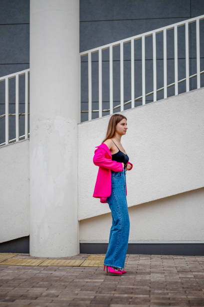 istock a young business girl in a bright colored jacket walks down the street with her jacket pulled down and wearing jeans 1757536392