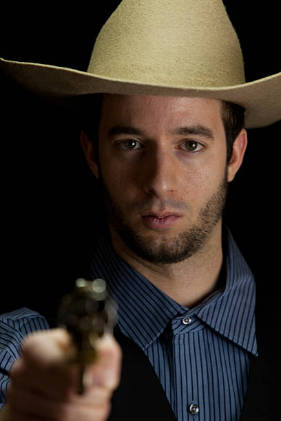 front-view of cowboy with gun (low-key studio shot)