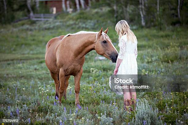 Bionda Giovane Donna Con Cavallo Palomino - Fotografie stock e altre immagini di Cowgirl - Cowgirl, Vestito da donna, Ambientazione esterna