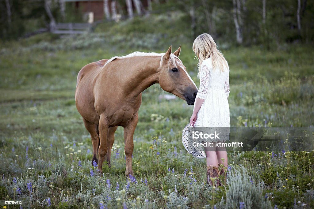 Jovem mulher loira com cavalo Palomino - Foto de stock de Vaqueira royalty-free