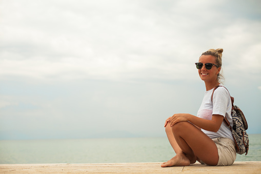 Happy smiling woman sitting at beach