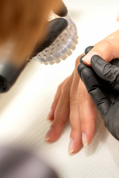les mains du maître manucure enlèvent la poussière des ongles avec une brosse pour nettoyer les ongles dans un salon de manucure. - nail file acrylic painting fingernail manicure photos et images de collection