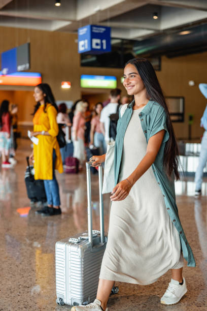 istock Young Woman Pulling Her Gray Suitcase At The Airport 1757565375