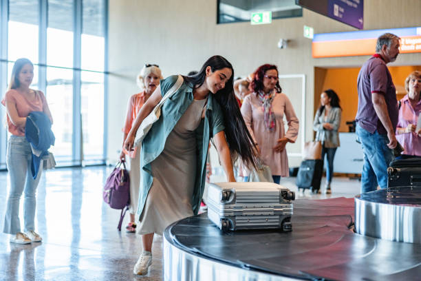 istock Attractive Young Woman Pulling Her Gray Suitcase From The Baggage Band 1757565404