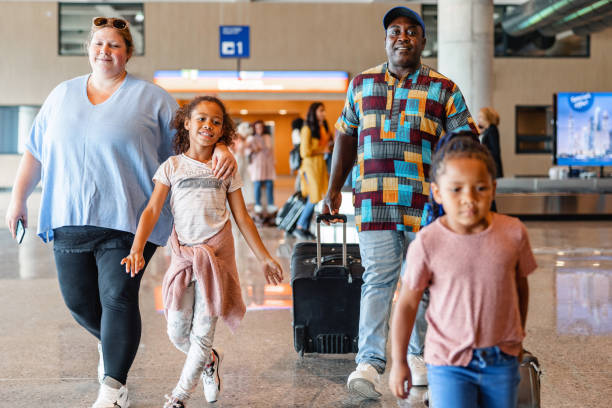 istock Diverse Family Pulling Suitcases While Walking Through The Airport 1757565459
