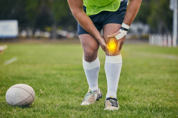 rugby, pain and man with knee injury on sports field for practice match, training and game outdoors. medical emergency, accident and athlete with x ray of joint inflammation, sprain and tendinitis - playing field effort outdoors human age imagens e fotografias de stock