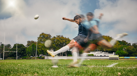 Rugby, blur and man kicking ball to score goal on field at game, match or practice workout. Sports, fitness and motion, player running to kick at poles on grass with energy and skill in team sport.
