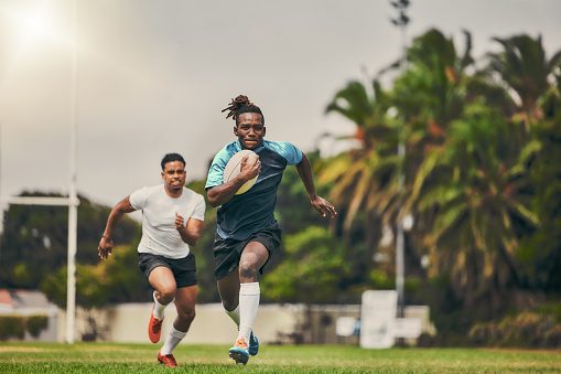 Rugby, chase and black man with ball running to score goal on field at game, match or practice workout. Sports, fitness and motion, player in action and blur on grass with energy and skill in sport.