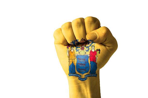 Fist painted in colors of us state new jersey flag Low key picture of a fist painted in colors of american state flag of new jersey jerseyan stock pictures, royalty-free photos & images