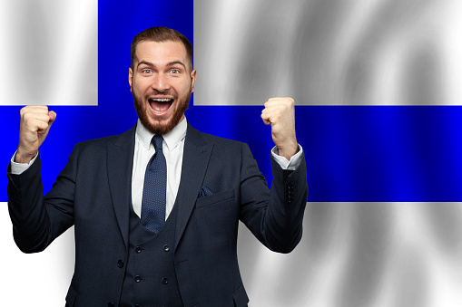 Finnish happy businessman on the background of flag of Finland Business, education, degree and citizenship concept