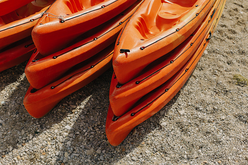 Colorful orange kayaks on a sandy beach in sunny day. Selective focus.