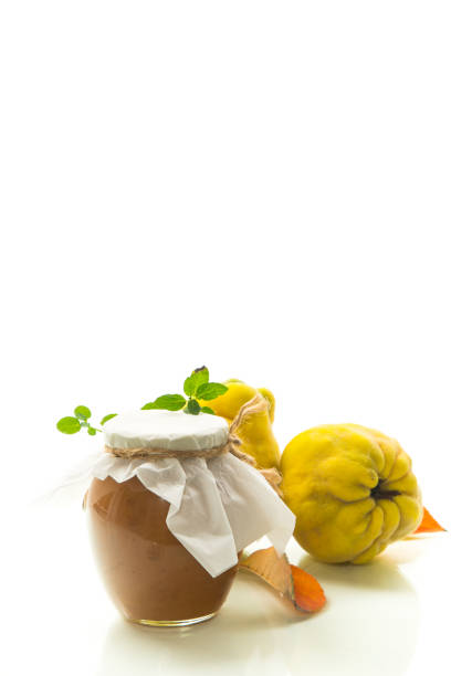 istock Ripe quince fruit with jam in a glass jar isolated on a white background. 1757612067