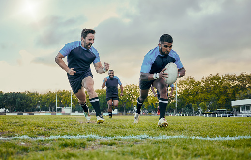 Rugby, sports and men training, score and exercise for balance, endurance and workout for wellness. Team, male athletes or players with ball, victory or winning on grass field, competition and active