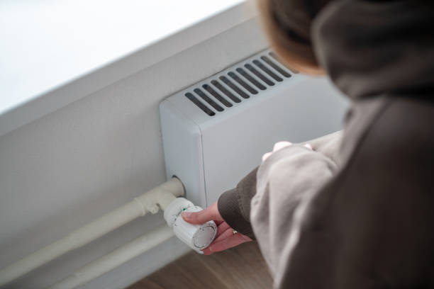 istock A woman adjusting thermostat on a radiator 1757621385