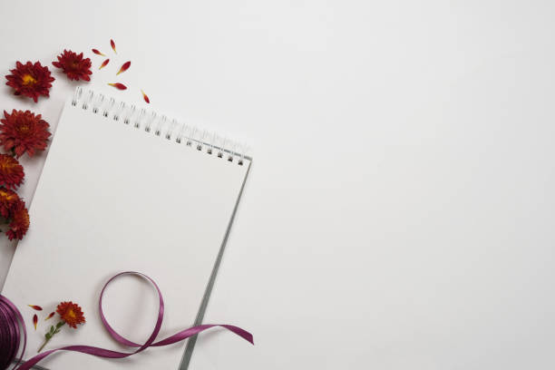 istock Blank book or notebook with red flowers and ribbon on white background. 1757623638