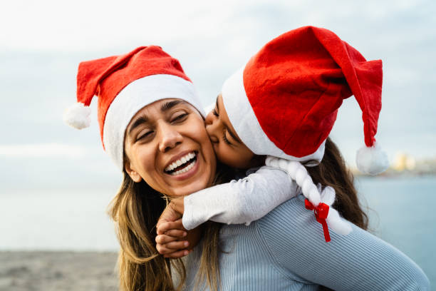 happy latin mother celebrating christmas time with her daughter - family and holidays concept - life events laughing women latin american and hispanic ethnicity imagens e fotografias de stock