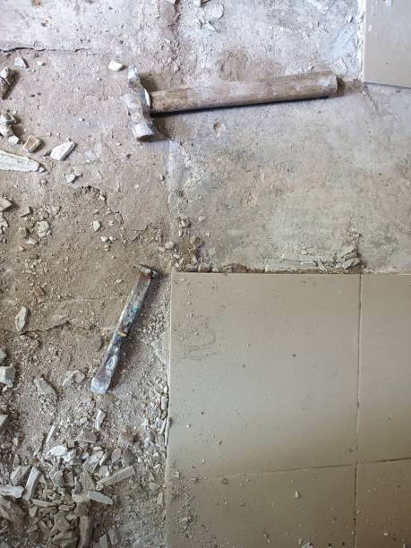 Old tools on floor. Dismantling old floor tiles. Renovations.Chisel and hammer on concrete slab. Very old construction tools. Preparing for repair work. Flooring restoration. Pieces of broken tile herramientas viejas en el suelo. desmontaje de baldosas viejas. reformas.cincel y martillo sobre losa de hormigón. herramientas de construcción muy antiguas. preparación para trabajos de reparación. restauración de pavimentos. pedazos de baldosas rota