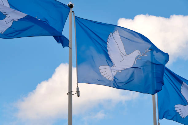 istock Three blue peace flags in a row printed with a dove and an alive branch 1757638699