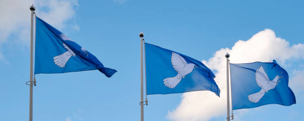 istock Three blue peace flags in a row printed with a dove and an alive branch 1757638701