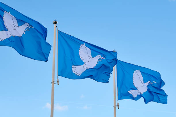 istock Three blue peace flags in a row printed with a dove and an alive branch 1757638704