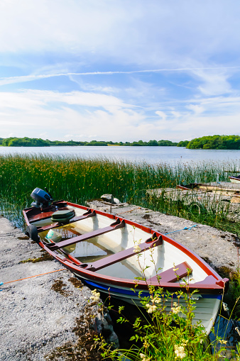 Rowing boat sits moored up at an Irish lough (lake)