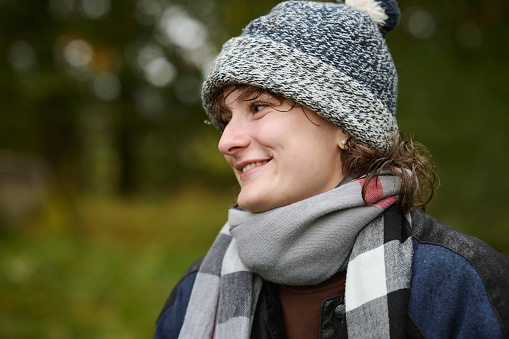 Portrait outdoors of young woman in autumn forest looking away