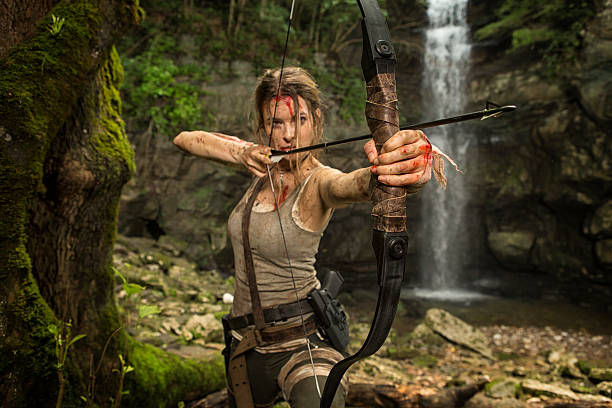 weibliche heldin in den dschungel jagen mit pfeil und bogen - archery bow arrow women stock-fotos und bilder