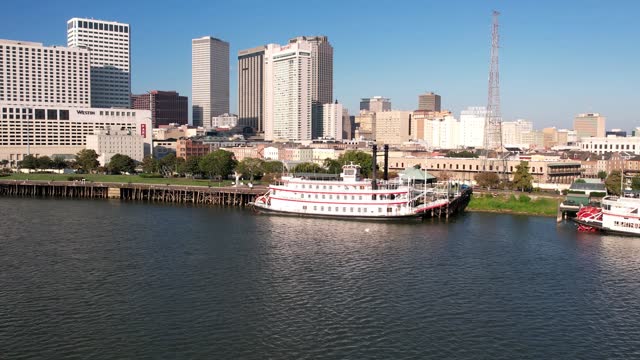 An aerial view of New Orleans zooming out onto the Mississippi River on a bright and sunny day