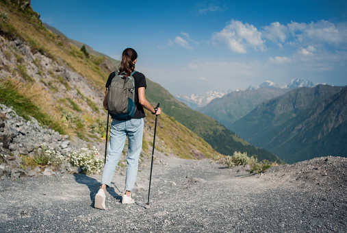 Girl walks in the mountains in summer. Trekking in the mountains.