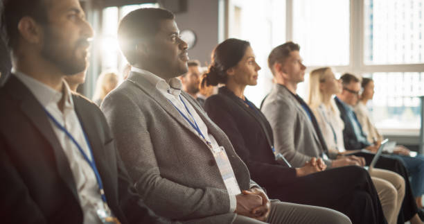 istock African Man Sitting in Crowded Auditorium at a Tech Conference. Professional Businessman Listening To Keynote. Specialist Watching Innovative Technology Presentation About New Software Solutions. 1757723858
