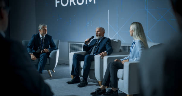 istock International Technology Conference: Host Asking Caucasian Male CEO a Question In Front Of Audience. Confident Man Delivering Inspirational Speech About Success And Diverse Attendees Listening. 1757744973