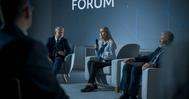 istock International Technology Conference: Male Host Asking Caucasian Female CEO a Question In Front Of Audience. Confident Woman Delivering Inspirational Speech And Diverse Attendees Listening Carefully. 1757745183