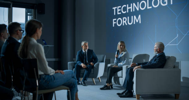 istock International Technology Conference: Male Host Asking Caucasian Female CEO a Question In Front Of Audience. Successful Woman Delivering Inspirational Speech And Diverse Attendees Listening Carefully. 1757745207