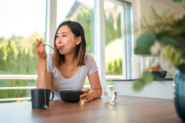 istock Female Asian IT Specialist Eating Small Breakfast Before Starting a Busy Day 1757745767