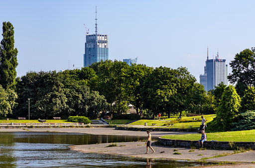 Warsaw, Poland - July 25, 2021: Panoramic view of Pole Mokotowskie field park with skyscrapers of Srodmiescie downtown district of Warsaw city center