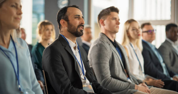 istock Multiethnic Male Technology Conference Attendee Sittign In Crowd And Listening to Presentation Of Innovative Gadget. Middle Eastern Man Looking For Investment Opportunities At International Tech Forum 1757747423