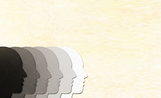 Group of faces in profile of different shades, representing multiracial diversity.
