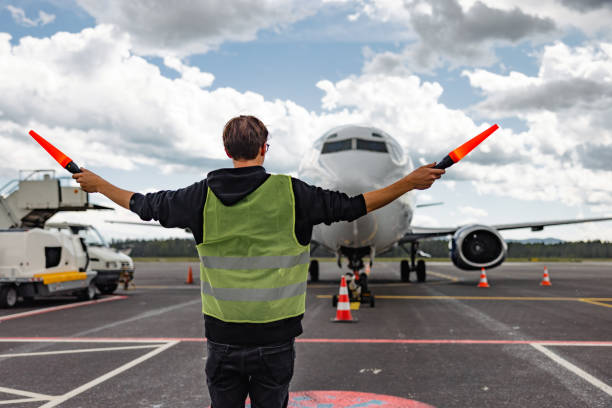 istock Caucasian Aircraft Marshalling Giving Signals To The Airplane Pilot 1757778169
