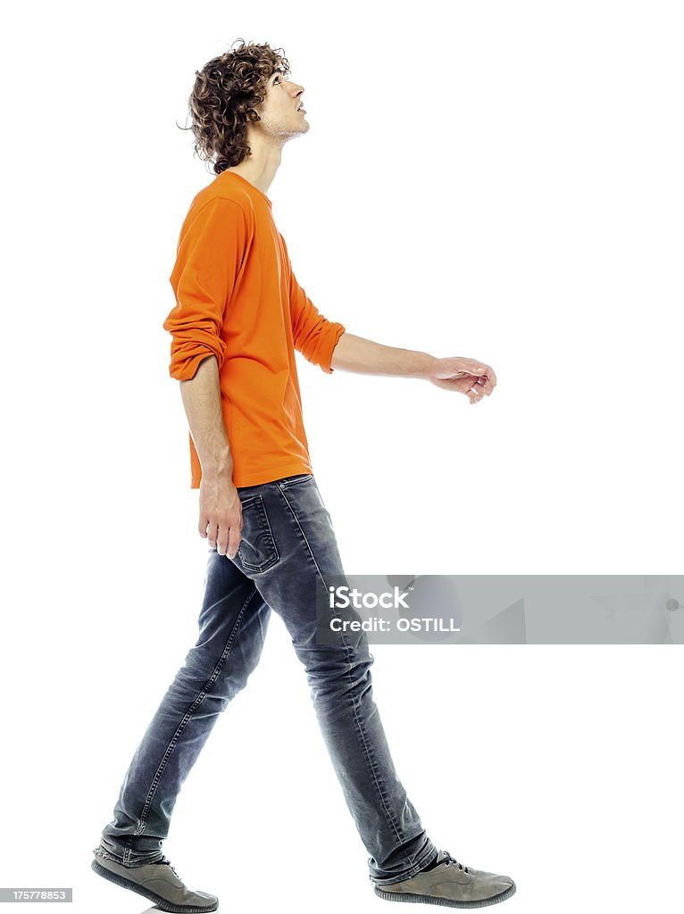 Side view of young man walking and looking upwards one young man caucasian walking side view looking up  in studio white background White Background Stock Photo