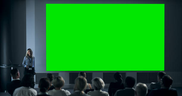 Corporate Event: Caucasian Female Tech CEO Giving Presentation On Green Screen Chromakey Projector Display To Colleagues In Conference Room Of Startup Office. Woman Talking About Business Objectives.