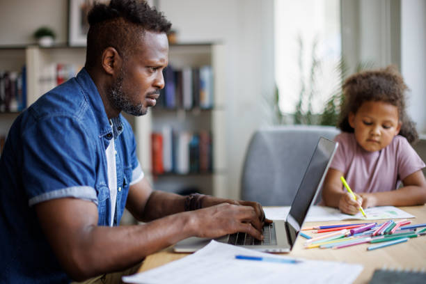 istock Father working on laptop while his daughter drawing beside him at home 1757822618