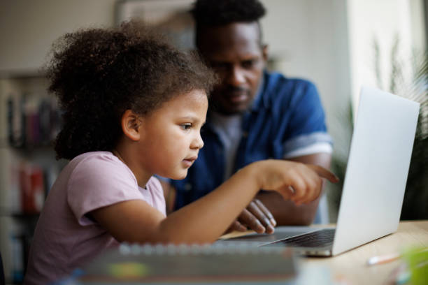 istock Father and daughter using laptop at home 1757822638