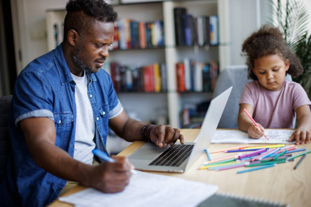 istock Father working on laptop while his daughter drawing beside him at home 1757822640