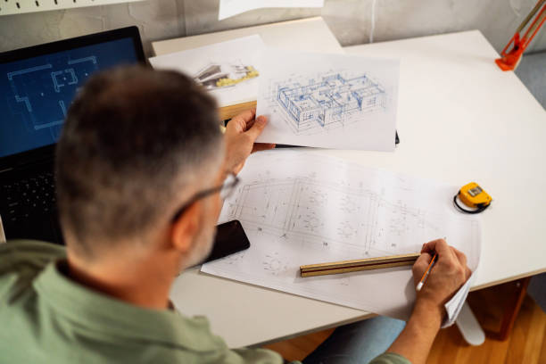 istock Unrecognizable Caucasian architect drawing an blueprint, while working from home office 1757832193