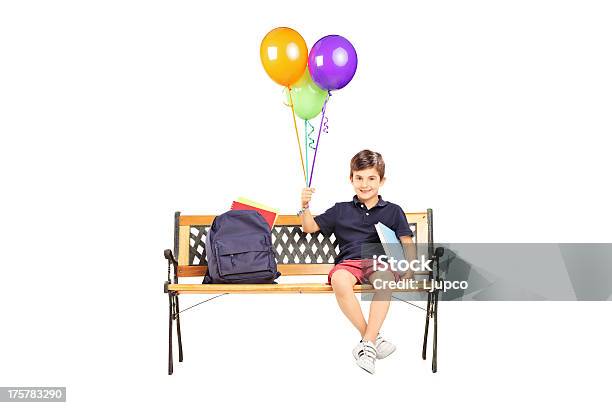 Schoolboy On Bench With Books Holding Balloons Stock Photo - Download Image Now - Backpack, Bag, Bench