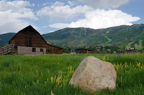 Steamboat Springs Barn and Ski Slopes in Summer The old barn at Steamboat Springs, Colorado is an iconic fixture.  Here it is photographed in Summer with a huge boulder in the foreground and the ski slopes on the mountain beyond. steamboat springs stock pictures, royalty-free photos & images